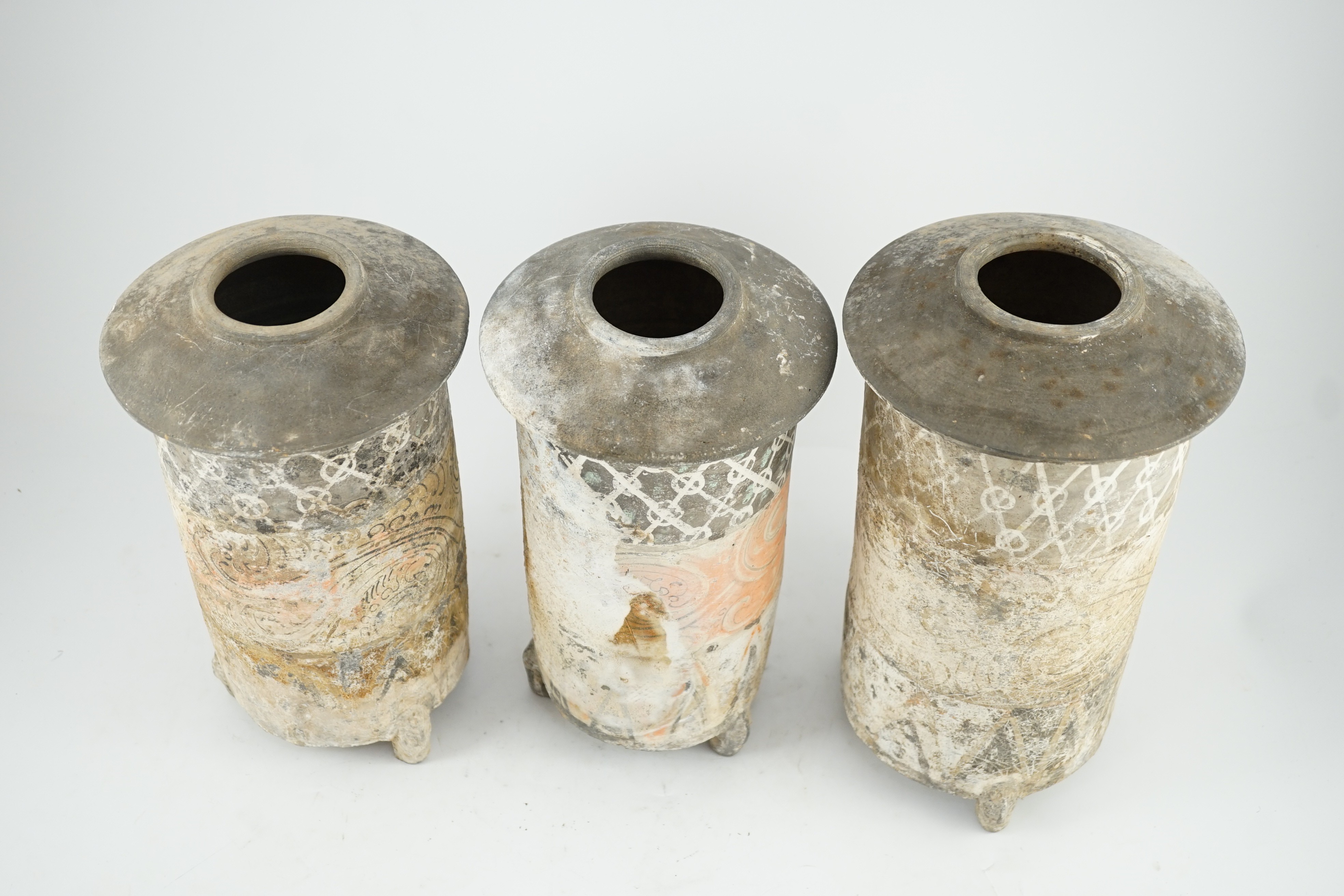 Three Chinese pigment painted grey pottery ‘granary’ jars, Han dynasty (200BCE - 220CE), 29.5 and 32cm high